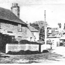 Fremlins have taken over as brewers and the landlord in 1938 was George Hurley. The store at the side of the Pub has been demolished and a lean-to added. This was home to The Shepherdswell Fire Brigade's hand cart, prior to the building of a new fire station in 1937. R. E. Miles, the blacksmith in 1938, is seen standing outside the open door of The Forge. To his left is the timetable for the East Kent Road Car Company's service to Dover. The Forge acted as a local agent. At the side of the building are pitchforks for either sale or repair.